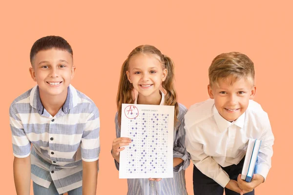 Bambini felici con foglio di risposta per test scolastici su sfondo a colori — Foto Stock
