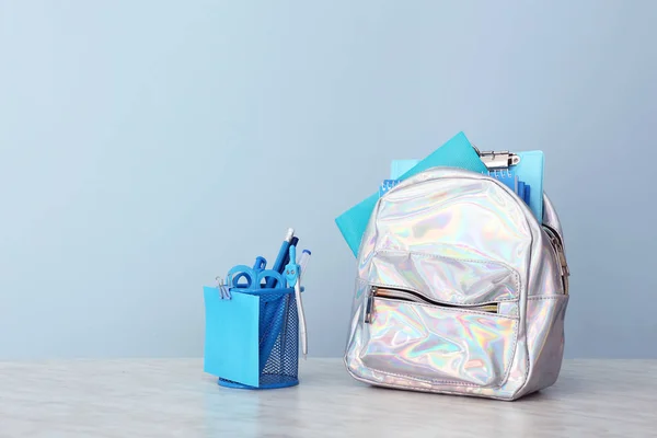 Iskolai hátizsák és írószer az asztalon színes háttér — Stock Fotó