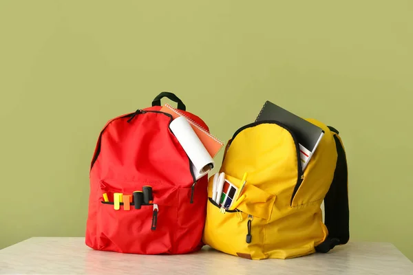 School rugzakken op tafel tegen achtergrondkleur — Stockfoto