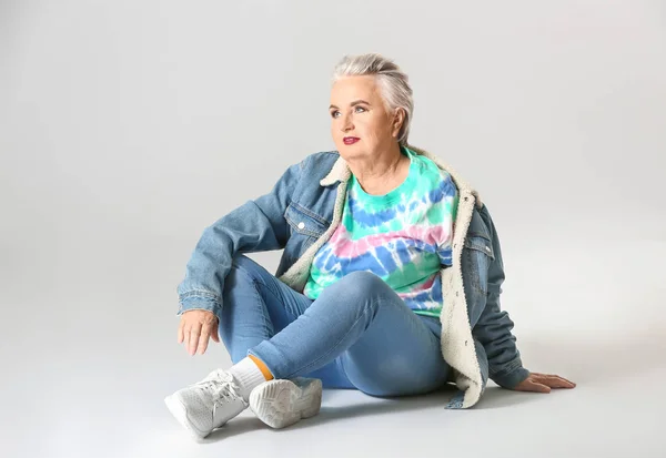 Mujer de edad avanzada con estilo sobre fondo gris — Foto de Stock