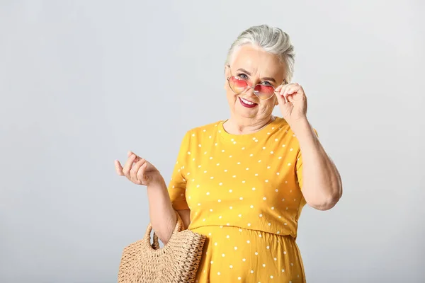 Stijlvolle oudere vrouw op grijze achtergrond — Stockfoto