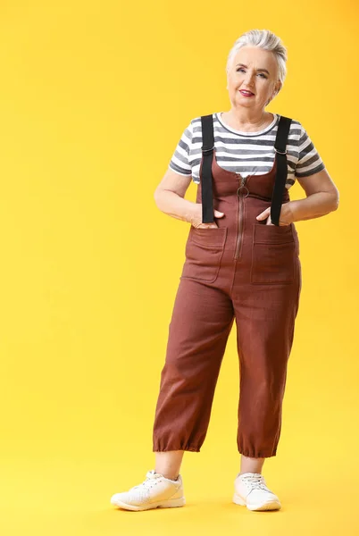 Stijlvolle oudere vrouw op kleur achtergrond — Stockfoto