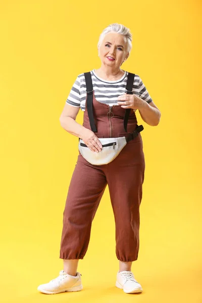 Elegante donna anziana su sfondo di colore — Foto Stock