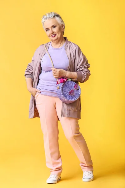 Stylish elderly woman on color background — Stock Photo, Image