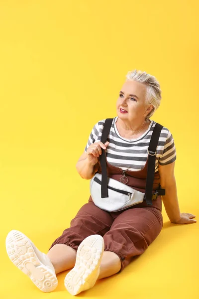 Stylish elderly woman on color background — Stock Photo, Image