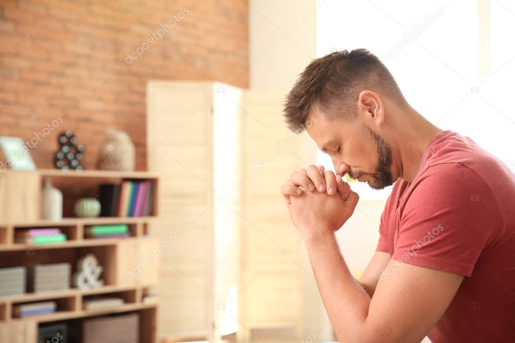 Religious man praying at home