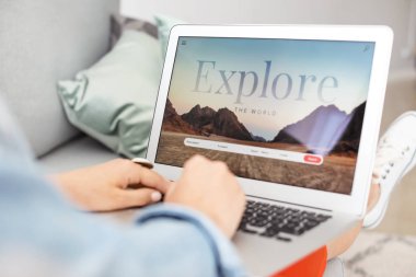 Dizüstü bilgisayar ile Kadın evde seyahat acentesi web sitesini ziyaret