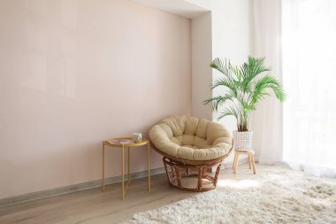 Pencereye yakın ışık odasında konforlu koltuk ve houseplant