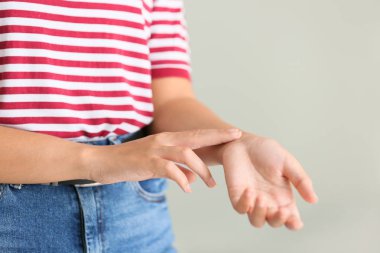 Kadın gri arka plan, closeup onu nabız kontrol