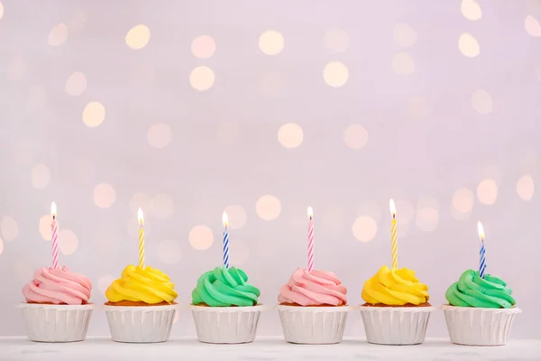 Assortment of tasty Birthday cupcakes against defocused lights — Stock Photo, Image