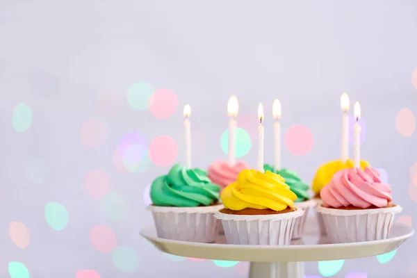 Assortment of tasty Birthday cupcakes on stand against defocused lights — Stock Photo, Image