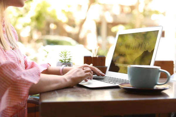 Mulher com laptop visitando site agência de viagens enquanto sentado no café — Fotografia de Stock
