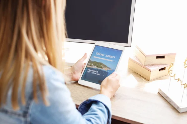 Vrouw met Tablet PC een bezoek aan de website van het reisbureau thuis — Stockfoto