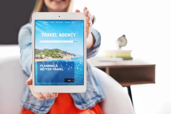 Frau mit Tablet-Computer besucht Reisebüro-Website zu Hause — Stockfoto
