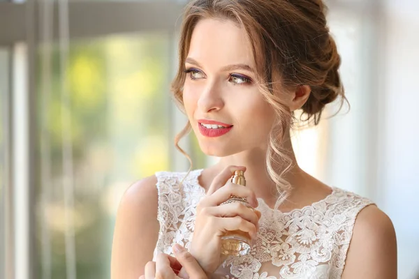 Красива молода наречена з пляшкою парфумів в приміщенні — стокове фото