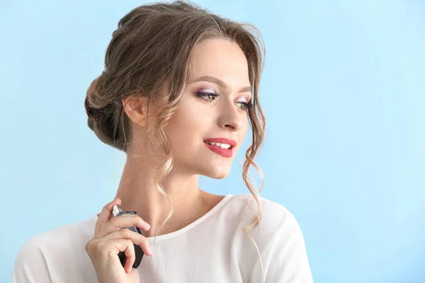 Gyönyörű fiatal nő, üveg parfüm, színes háttérrel — Stock Fotó