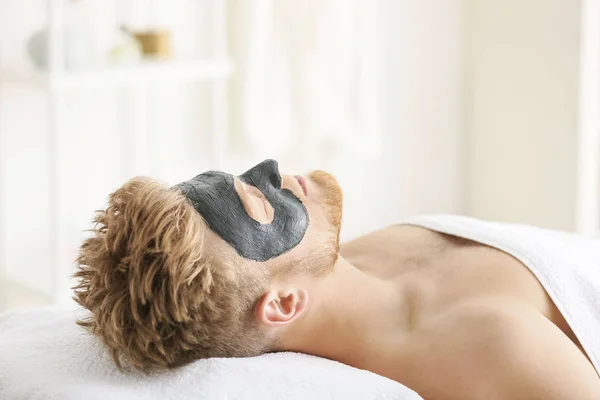 Handsome man with mask on face in spa salon — Stock Photo, Image