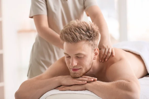 Guapo joven recibiendo masaje en el salón de spa —  Fotos de Stock