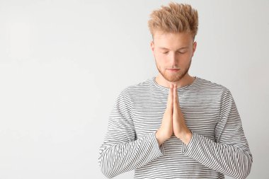 Tanrı'ya dua ışık arka plan üzerinde dini genç adam