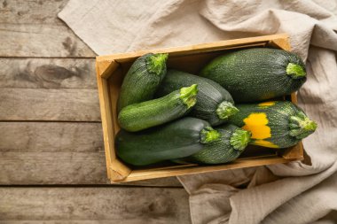 Ahşap masa üzerinde taze kabak squashes ile Sandık