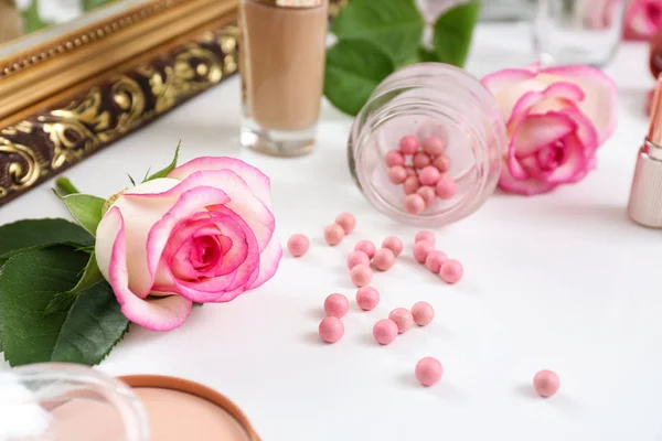 Flores de rosa com cosméticos de maquiagem na mesa de vestir — Fotografia de Stock