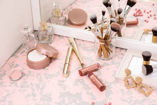 Makeup cosmetics with brushes on dressing table — Stock Photo, Image