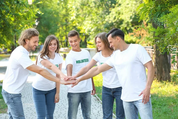 Grupo de voluntarios poniendo las manos juntas al aire libre — Foto de Stock