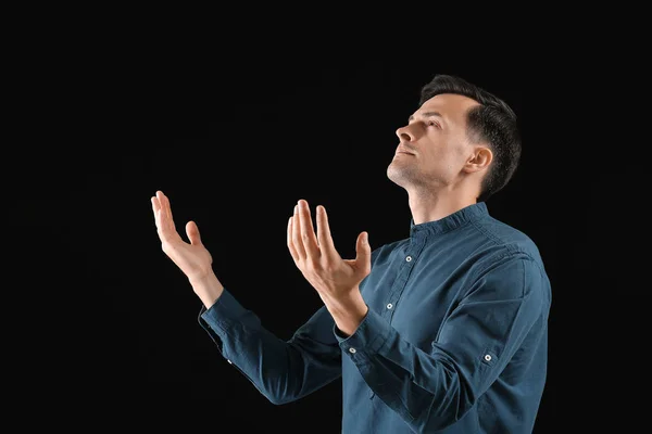 Religious man praying to God on dark background — Stock Photo, Image