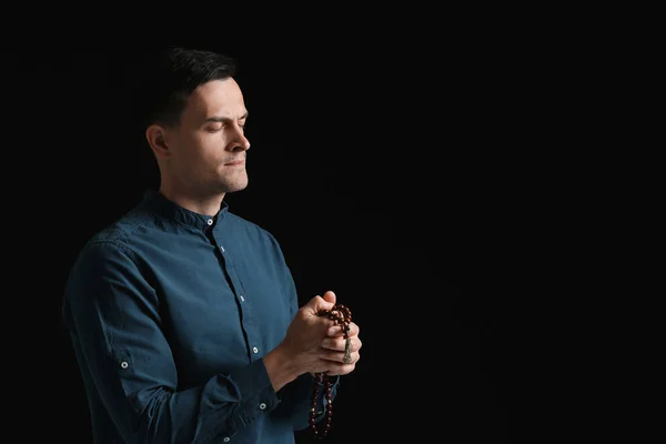 Religious man praying to God on dark background — Stock Photo, Image