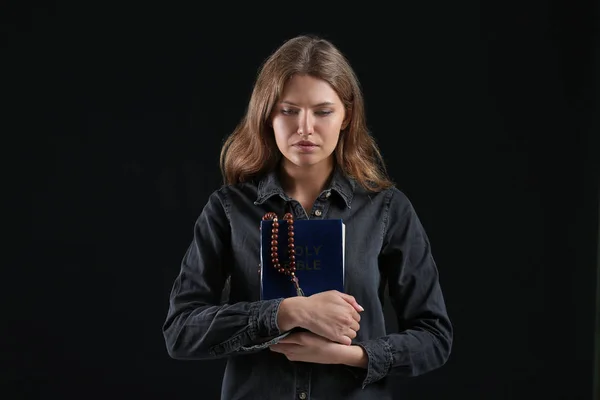 Religious young woman praying to God on dark background — Stock Photo, Image