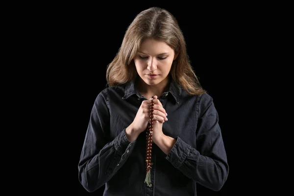 Θρησκευτική νεαρή γυναίκα προσεύχεται στο Θεό σε σκοτεινό φόντο — Φωτογραφία Αρχείου