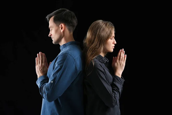 Casal religioso orando a Deus em fundo escuro — Fotografia de Stock