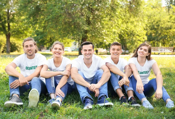 Група добровольців, що сидять на зеленій траві на відкритому повітрі — стокове фото