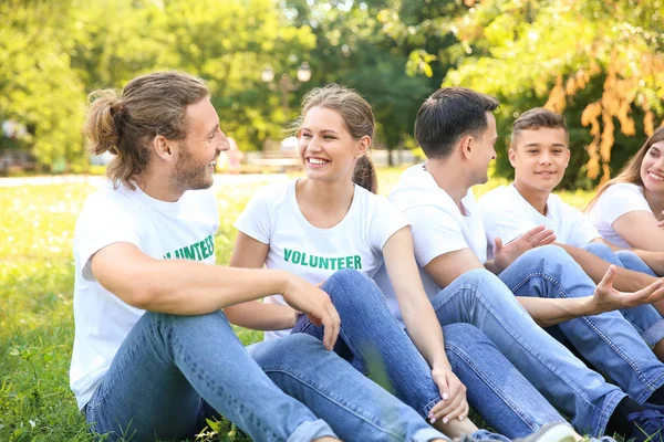 Grupo de voluntarios sentados en césped verde al aire libre — Foto de Stock