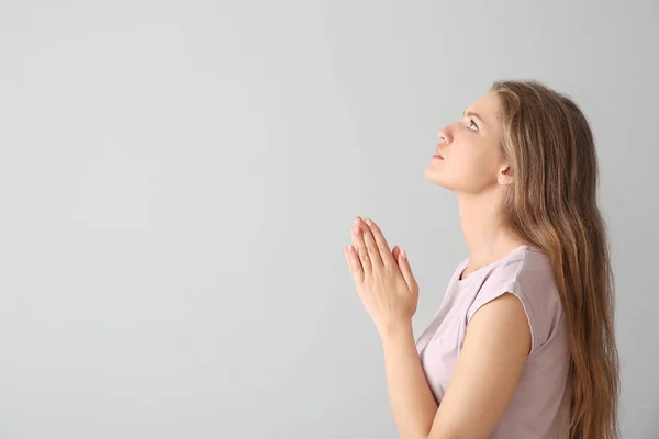 Релігійна молода жінка молилася до Бога на світлому фоні — стокове фото