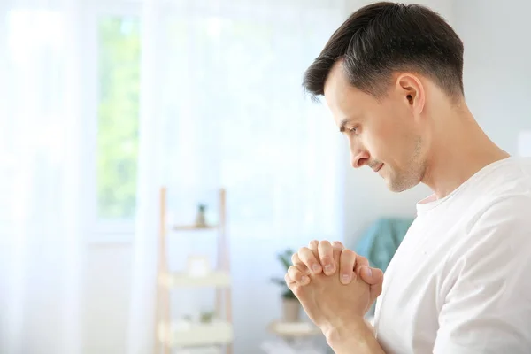 Religious man praying to God at home — Stock Photo, Image