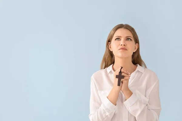 Religiosa joven rezando a Dios sobre fondo de color claro — Foto de Stock