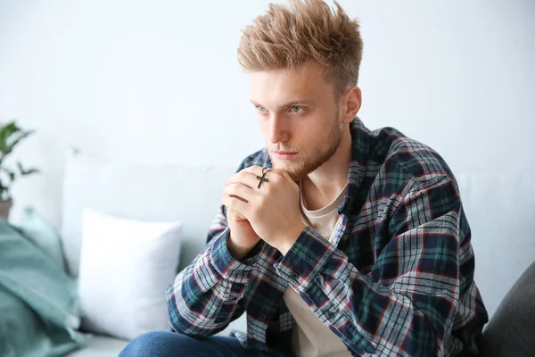 Religious young man praying to God at home — Stock Photo, Image