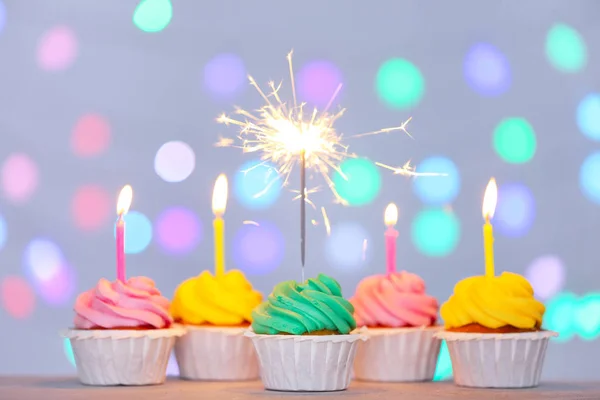 Sabrosos cupcakes de cumpleaños contra luces desenfocadas —  Fotos de Stock