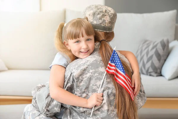 自宅で彼女の小さな娘を抱きしめるアメリカ軍の幸せな女性兵士 — ストック写真