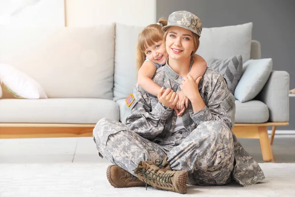 Lycklig kvinnlig soldat med sin lilla dotter hemma — Stockfoto