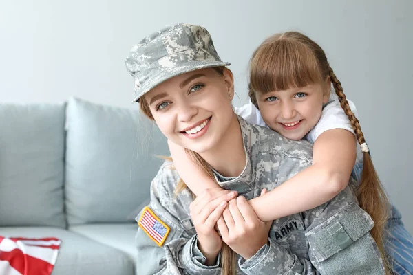 Glückliche Soldatin mit ihrer Tochter zu Hause — Stockfoto