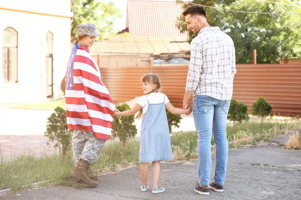 Feliz soldado mujer con bandera de EE.UU. y su familia al aire libre — Foto de Stock