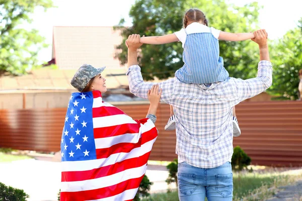 Feliz soldado mujer con bandera de EE.UU. y su familia al aire libre — Foto de Stock