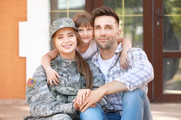 Lycklig kvinnlig soldat med sin familj utomhus — Stockfoto