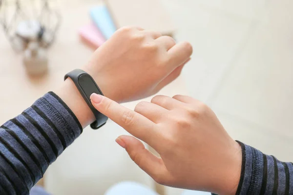 Woman checking with fitness band checking her pulse at home, closeup — Stock Photo, Image