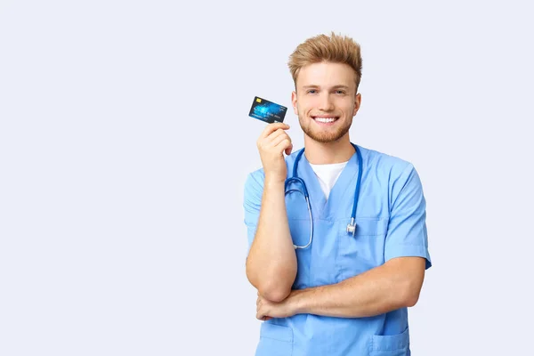 Happy male doctor with credit card on white background — Stock Photo, Image