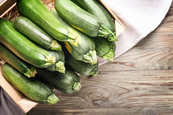 Kiste mit frischen Zucchini-Kürbissen auf Holztisch — Stockfoto