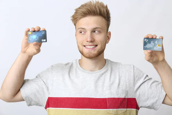 Szczęśliwy młody człowiek z kartami kredytowymi na białym tle — Zdjęcie stockowe