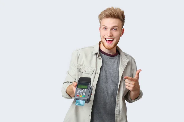 Szczęśliwy młody człowiek z terminalu płatności kartą kredytową na białym tle — Zdjęcie stockowe